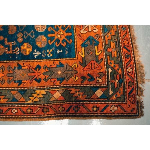 168 - An early 20th century Caucasian Kazak rug, with four square medallions on an indigo blue ground with... 