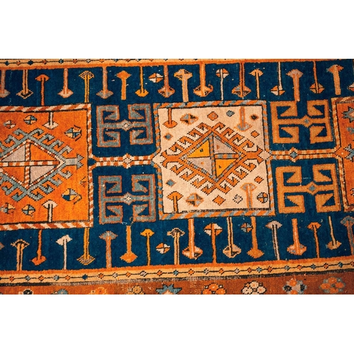 168 - An early 20th century Caucasian Kazak rug, with four square medallions on an indigo blue ground with... 