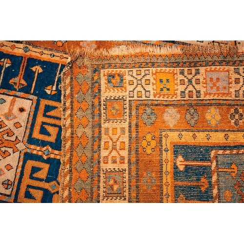 168 - An early 20th century Caucasian Kazak rug, with four square medallions on an indigo blue ground with... 