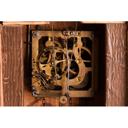 173 - An early 20th century carved walnut cuckoo wall clock with a pair of cast pine cone weights and leaf... 