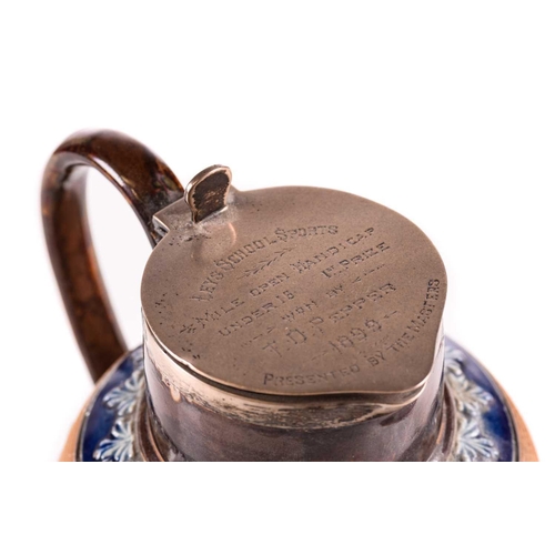 217 - A late 19th century Doulton Lambeth stoneware water jug, with a hinged silver cover bearing a presen... 