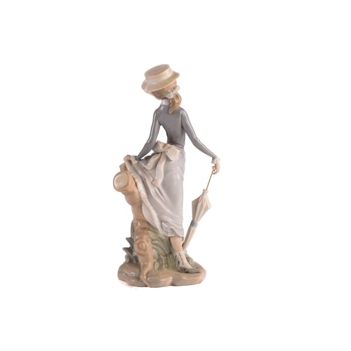 220 - Two Lladro figural table lamp bases, each modelled with a girl holding a basket, 39 cm high, togethe... 