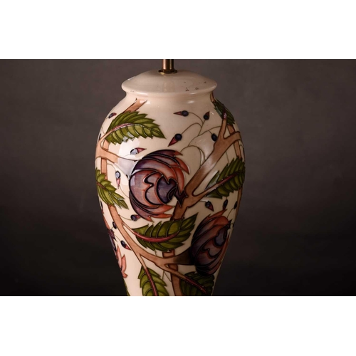 226 - A contemporary large Moorcroft baluster table lamp, with tube-lined floral decoration on a cream gro... 