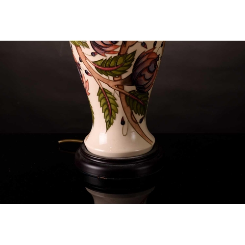 226 - A contemporary large Moorcroft baluster table lamp, with tube-lined floral decoration on a cream gro... 