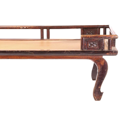 62 - A 19th-century Chinese elmwood opium bed with an open gallery back with lotus flower panel infills a... 