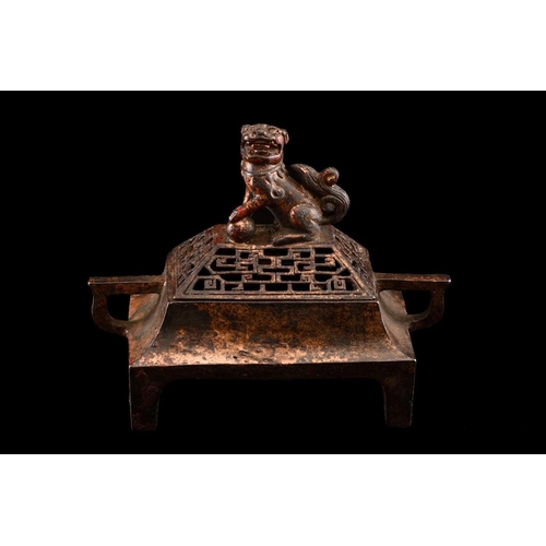 79 - A Chinese bronze censer, of rectangular form, the pierced cover surmounted by a temple lion, the inv... 