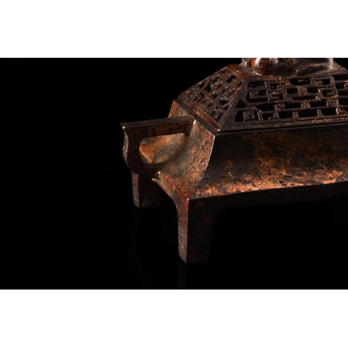 79 - A Chinese bronze censer, of rectangular form, the pierced cover surmounted by a temple lion, the inv... 