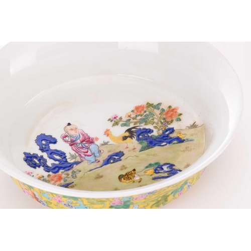 96 - A Chinese porcelain high sided dish, painted with a young boy beside a chicken and chicks between ro... 