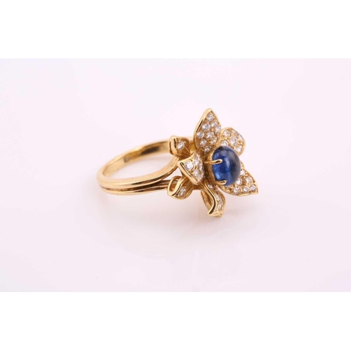 20 - An 18ct gold sapphire and diamond flower ring, comprises an oval sapphire cabochon with a high dome,... 