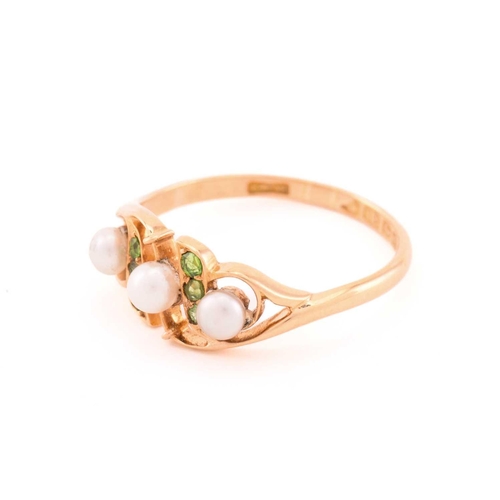 29 - A pearl and demantoid garnet dress ring in 18ct gold, comprises three off round pearls where the one... 