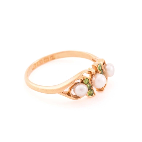 29 - A pearl and demantoid garnet dress ring in 18ct gold, comprises three off round pearls where the one... 