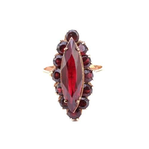 36 - A synthetic ruby and garnet dress ring, comprises a marquise-shaped synthetic ruby claw-set on a rai... 