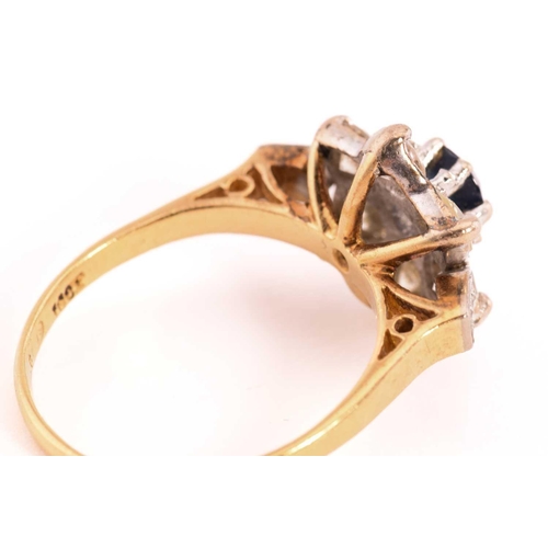 46 - A sapphire and diamond flower head ring in 18ct gold, composed of a central faceted sapphire approxi... 