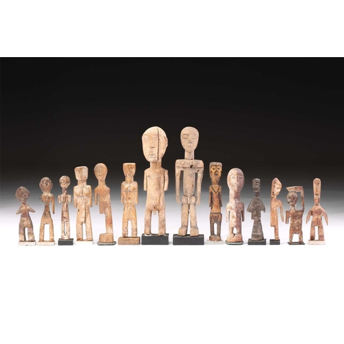 107 - A collection of fourteen Adan/Ewe standing figures, Ghana/Togo/Benin, some painted in coloured pigme... 