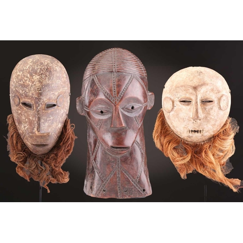 115 - A Tabwa mask, Tanzania, with linear coiffure, and scarifications, the wood with a red hue, 42cm; a L... 