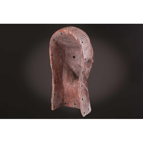 115 - A Tabwa mask, Tanzania, with linear coiffure, and scarifications, the wood with a red hue, 42cm; a L... 