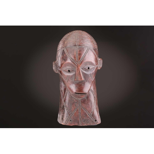 115 - A Tabwa mask, Tanzania, with linear coiffure, and scarifications, the wood with a red hue, 42cm; a L... 