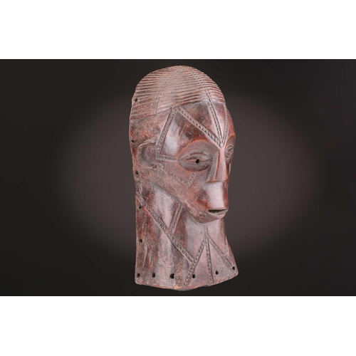 115 - A Tabwa mask, Tanzania, with linear coiffure, and scarifications, the wood with a red hue, 42cm; a L... 