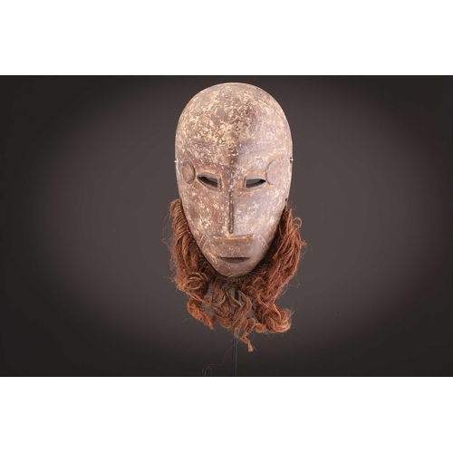115 - A Tabwa mask, Tanzania, with linear coiffure, and scarifications, the wood with a red hue, 42cm; a L... 