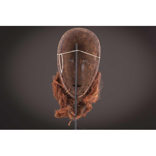 115 - A Tabwa mask, Tanzania, with linear coiffure, and scarifications, the wood with a red hue, 42cm; a L... 