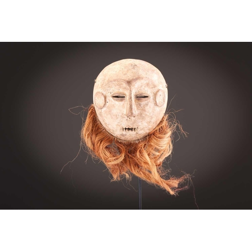 115 - A Tabwa mask, Tanzania, with linear coiffure, and scarifications, the wood with a red hue, 42cm; a L... 