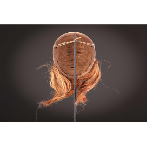 115 - A Tabwa mask, Tanzania, with linear coiffure, and scarifications, the wood with a red hue, 42cm; a L... 