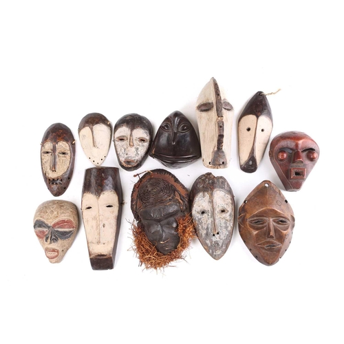 73 - A collection of twelve West African passport type masks, to include Songye, Hembe Lega, and Tchokwe,... 