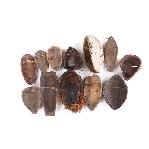 73 - A collection of twelve West African passport type masks, to include Songye, Hembe Lega, and Tchokwe,... 