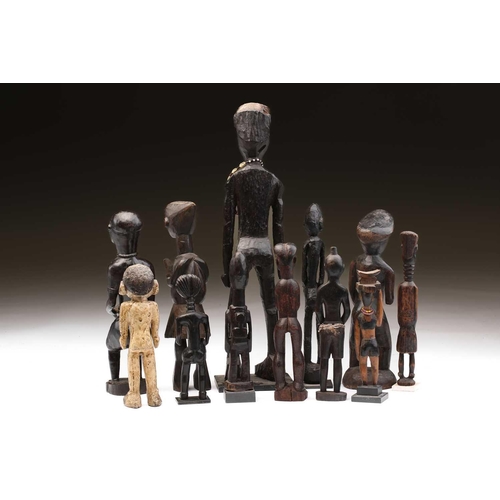80 - A collection of twelve principally West African standing male and female figures, to include Agni, A... 