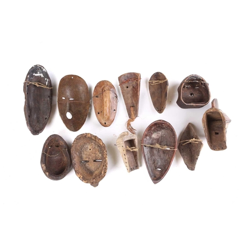 81 - A collection of twelve West Africa passport type masks, to include Songye, a Lega hand held Lukwakon... 