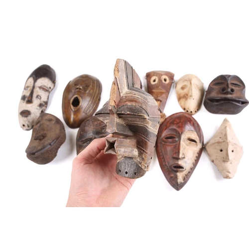 81 - A collection of twelve West Africa passport type masks, to include Songye, a Lega hand held Lukwakon... 