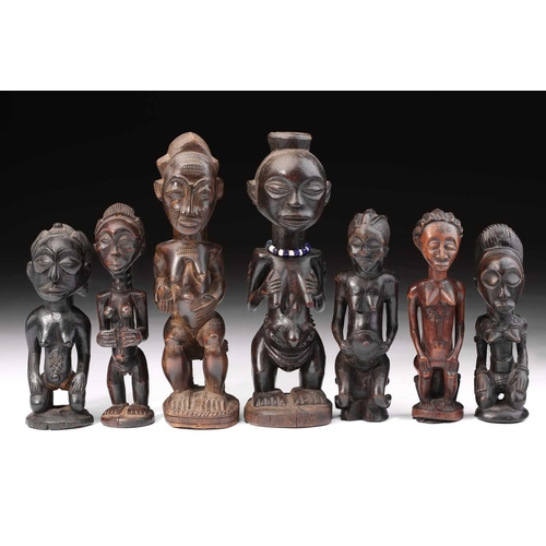 83 - A group of seven Baule fertility figures, Ivory Coast, carved standing, seated and kneeling, each wi... 