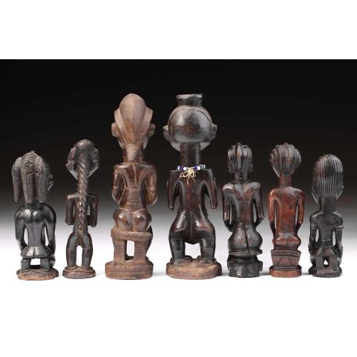 83 - A group of seven Baule fertility figures, Ivory Coast, carved standing, seated and kneeling, each wi... 