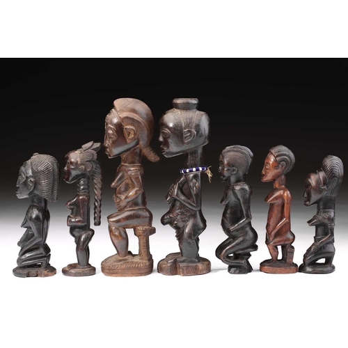 83 - A group of seven Baule fertility figures, Ivory Coast, carved standing, seated and kneeling, each wi... 