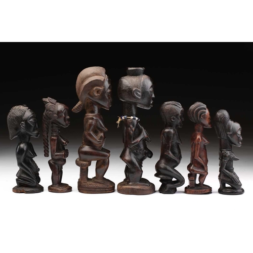 83 - A group of seven Baule fertility figures, Ivory Coast, carved standing, seated and kneeling, each wi... 