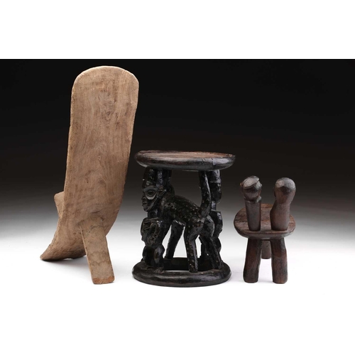 86 - A Bamileke stool, Cameroon, the circular top supported by two male figures flanking a leopard, colou... 