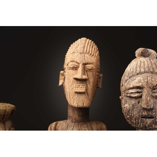 92 - An Indonesian standing female figure, the linear coiffure terminating in a curl, on a wood base, and... 