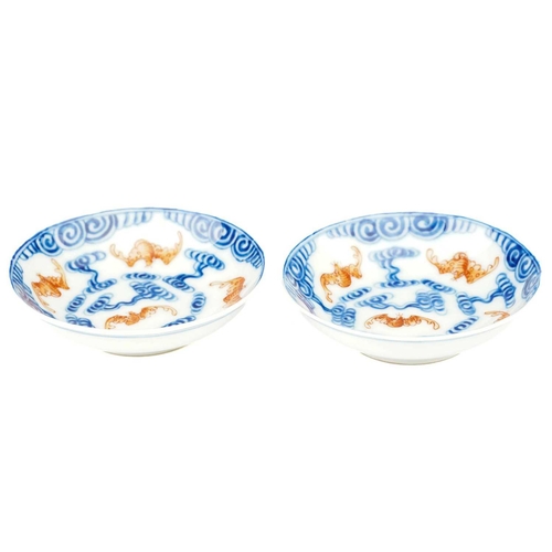 119 - A pair of Chinese porcelain Wufu dishes, 20th century, painted with five red bats flying amongst blu... 