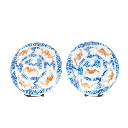 119 - A pair of Chinese porcelain Wufu dishes, 20th century, painted with five red bats flying amongst blu... 