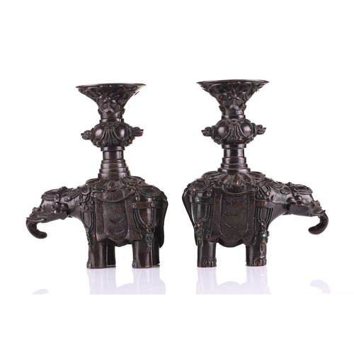 181 - A pair of Chinese bronze caparisoned elephants, Qing, 19th century, supporting a Gu vase upon its ba... 