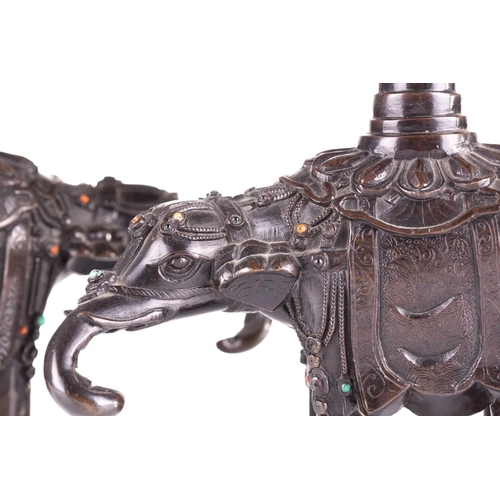 181 - A pair of Chinese bronze caparisoned elephants, Qing, 19th century, supporting a Gu vase upon its ba... 