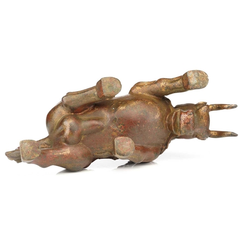 198 - A Chinese bronze figure of a charging bull, wearing a band of good luck charms, traces of red pigmen... 