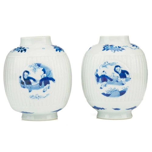 88 - A pair of Chinese blue & white barrel shape vases, with round panels depicting boys at play, against... 