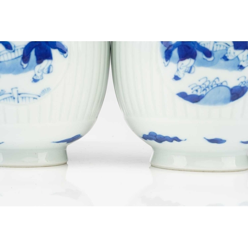 88 - A pair of Chinese blue & white barrel shape vases, with round panels depicting boys at play, against... 