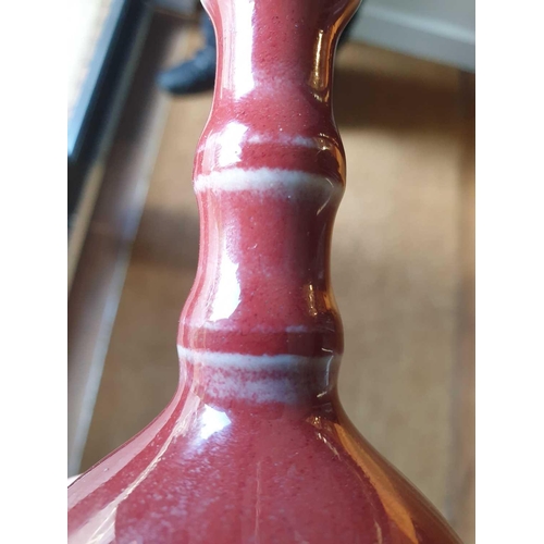 89 - A Chinese small sang de boeuf bottle vase, with bamboo-effect neck, 11.8 cm high.