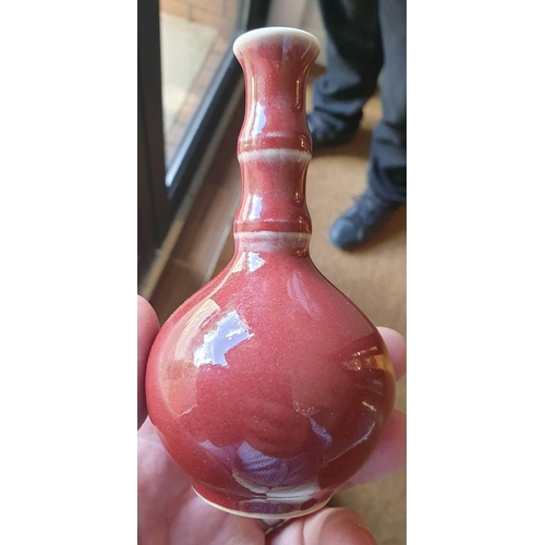 89 - A Chinese small sang de boeuf bottle vase, with bamboo-effect neck, 11.8 cm high.