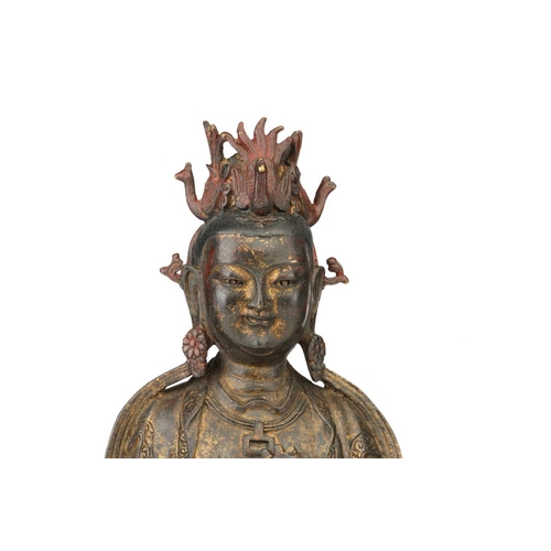 92 - A Chinese bronze figure of Guanyin, seated wearing long robes and holding a mirror, traces of red pi... 