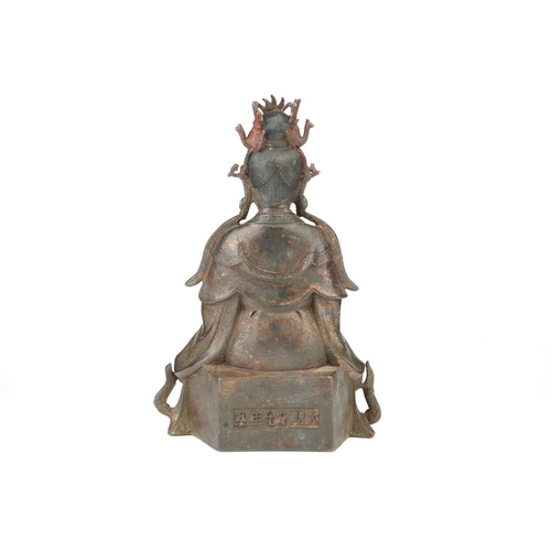 92 - A Chinese bronze figure of Guanyin, seated wearing long robes and holding a mirror, traces of red pi... 