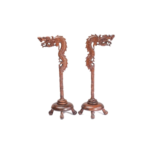 170 - A close pair of Chinese carved wood lantern stands in the form of dragons with turned dome bases and... 