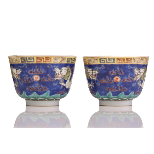 175 - A pair of Chinese porcelain dragon cups, painted with opposing white dragons facing a pearl amongst ... 